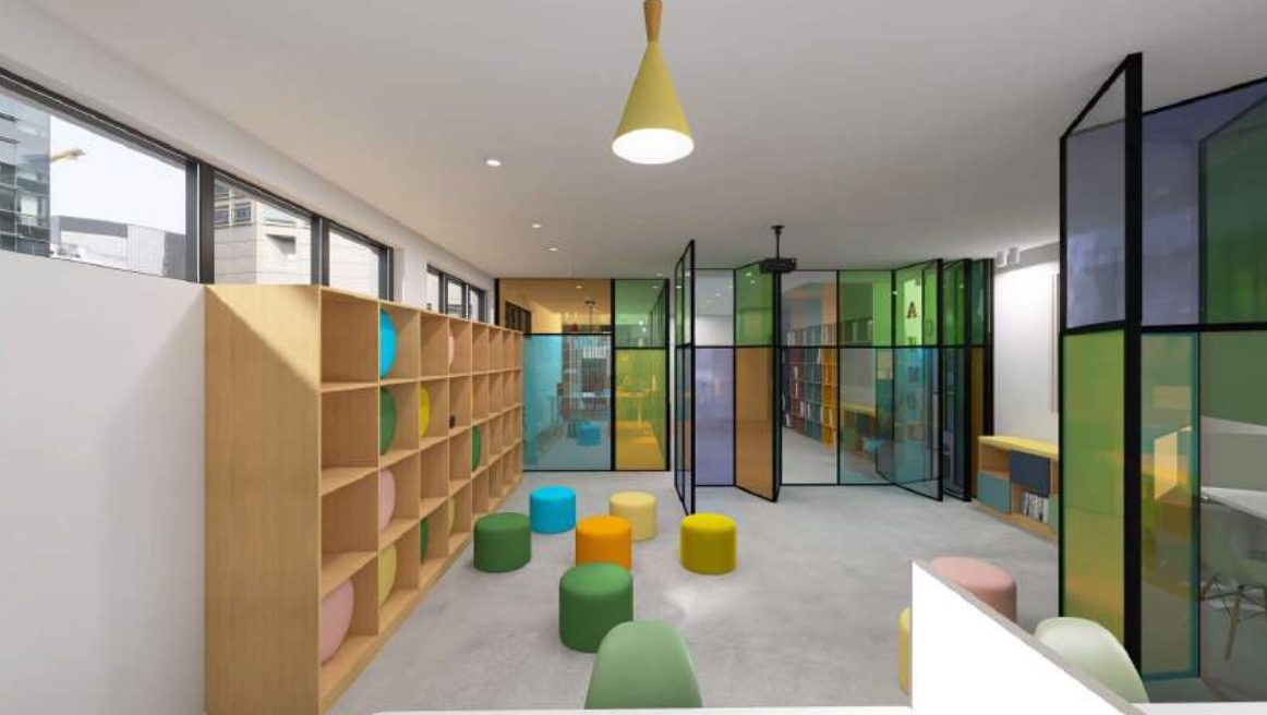 Render di uno spazio con sedute morbide e librerie